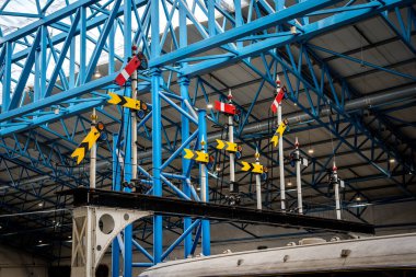 A group of historic semaphore rail signals on a gantry in the UK with lower quadrant signalling clipart