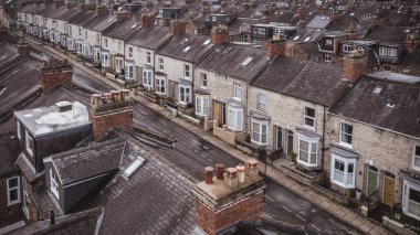 An aerial view above the rooftops of run down back to back terraced houses on a large residential estate in the North of England clipart