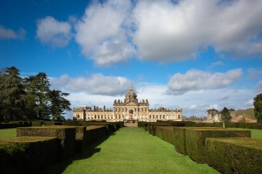 CASTLE HOWARD, YORK, UK - 23 Mart 2024. Howardian Hills 'teki Howard Stately House Kalesi' nin resmi bahçelerindeki Atlas Çeşmesi manzarası. Güneş ışığı ve mavi gökyüzü.