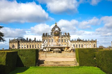 CASTLE HOWARD, YORK, UK - 23 Mart 2024. Howardian Hills 'teki Howard Stately House Kalesi' nin resmi bahçelerindeki Atlas Çeşmesi manzarası. Güneş ışığı ve mavi gökyüzü.