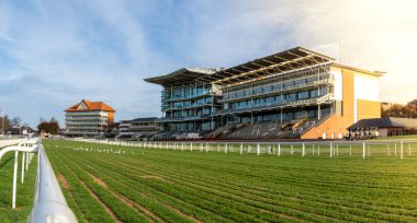 YORK RACECOURSE, YORK, UK - OCTOBER 26, 2024. Panorama landscape of York Racecourse buildings with horse racing track and the home straight and winning post overlooked by the stadium Grandstand clipart