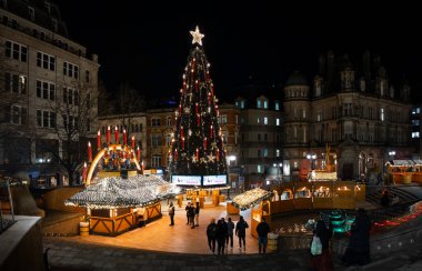 VICTORIA Squarare, BIRMINGHAM, İngiltere - 26 Kasım 2024. Birmingham, İngiltere 'de Victoria Meydanı' ndaki Alman Noel Pazarı 'ndaki renkli pazar yerleri ve gece renkli Noel ışıkları.