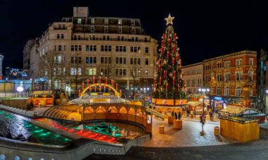 VICTORIA SQUARE, BIRMINGHAM, UK - NOVEMBER 25, 2024.  Landscape panorama of colourful market stalls at The German  Christmas Market in Victoria Square, Birmingham, UK with colourful Christmas lights at night clipart