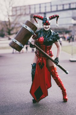 BIRMINGHAM, İngiltere - 30 Kasım 2024. Batman bayiliğinden Harley Quinn gibi giyinmiş bir kadın oyuncu bir komedi gösterisinde PVC kostümüyle gülüyor ve eğleniyor.