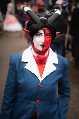 A close up portrait of a pretty female cosplayer dressed as an Anime character from the Hazbin Hotel smiling and having fun at a UK Comic Con event clipart