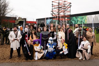 BIRMINGHAM, İngiltere - 30 Kasım 2024. En sevdikleri Star Wars karakterleri gibi gülen ve gülümseyen bir grup kadın ve erkek kozmosu.