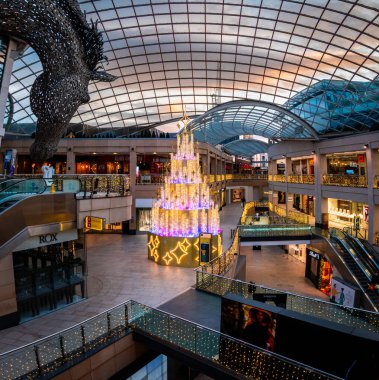 Leeds, İngiltere - 24 Aralık 2024. Noel zamanı Leeds şehir merkezindeki Üçlemeci Alışveriş Merkezi 'nin içi dekorasyonlar ve aydınlatılmış Noel ağacıyla boks günü satışlarına hazır.