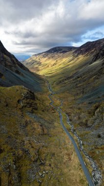 Cumbria, İngiltere 'deki İngiliz Lake District Ulusal Parkı' ndaki Honister Geçidi 'nin dikey hava manzarası. Etrafındaki dağlar Honister Kayrak Madeni' ne doğru ilerliyor.