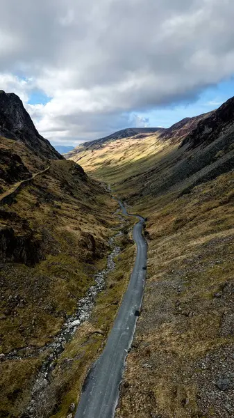 Cumbria, İngiltere 'deki İngiliz Lake District Ulusal Parkı' ndaki Honister Geçidi 'nin dikey hava manzarası. Etrafındaki dağlar Honister Kayrak Madeni' ne doğru ilerliyor.