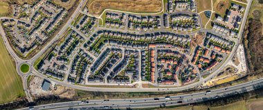 İngiltere 'de, konut sıkıntısı nedeniyle yeşil kuşak arazisi üzerine inşa edilmiş, küçük bahçeli, yeni inşa edilebilir banliyö evleri bloğunun hemen üzerindeki hava manzarası.