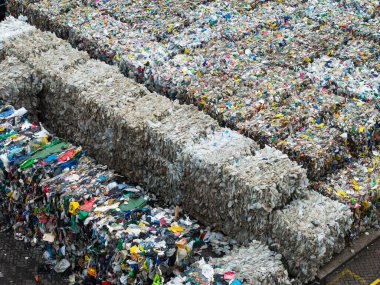 Polimer gıda ambalajı ve süt kutuları da dahil olmak üzere plastik atık balyalarının hava görüntüsü fotokopi alanı olan bir atık yönetim fabrikasında geri dönüşüme hazır