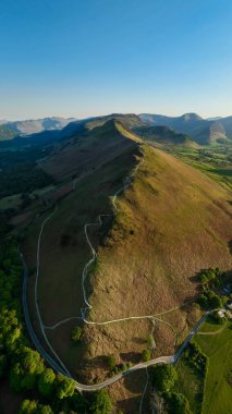 Manesty Ormanı ve Newlands Vadisi 'ndeki İngiliz Lake District Ulusal Parkı' ndaki Catbell Dağı tepesi boyunca yürüme yolunun dikey manzarası.