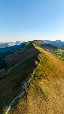 Manesty Ormanı ve Newlands Vadisi 'ndeki İngiliz Lake District Ulusal Parkı' ndaki Catbell Dağı tepesi boyunca yürüme yolunun dikey manzarası.