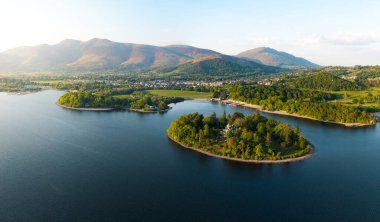 Derwent Adası 'nın feribot iskelesi ve İngiltere' nin Keswick Lake District kasabası ile Derwent Water sahil şeridine yakın olan panoramik manzarası gün batımında