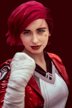 Savaşa hazır ve yumrukları havada Vi gibi giyinmiş güzel bir kız oyuncu kameraya özgüvenle bakıyor.