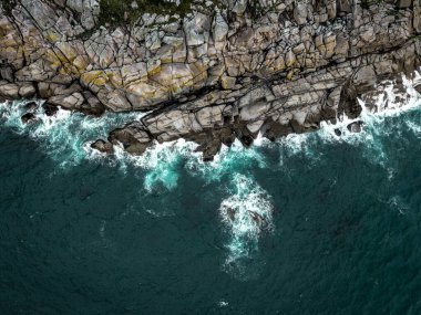 Kıyı erozyonu görüntüsünde sert granit kayalıklar ile kayalık kayalıkların üzerinden direkt olarak dalgalı denizlere doğru hava manzarası