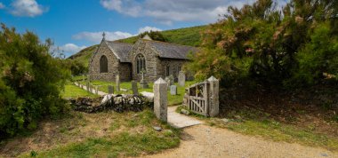 GUNWALLOE, CORNWALL, UK - JUNE 5, 2025.  The small medieval church of St Wynwalloe at Gunwalloe Church Cove in Cornwall is a popular tourist destination and the scene of film and TV productions