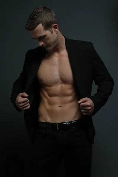 Takım elbiseli yakışıklı adam poz veriyor.