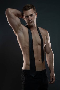 Kravatlı ve kolları başının arkasında olan tişörtsüz bir milyarder.