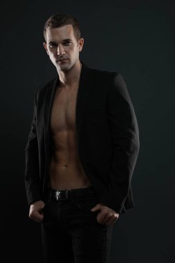 Ceketsiz, erkek manken. Karın kaslarını gösteriyor. 