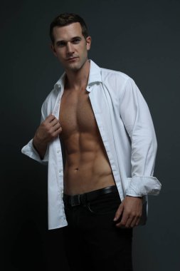 Karın kaslarını gösteren seksi genç model açılış gömleği.