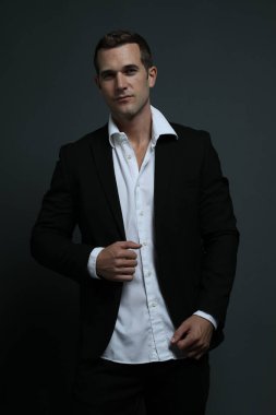 Zarif takım elbiseli adam ileriye bakıyor.