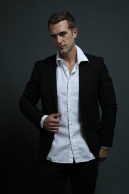 Seksi adam ceketini açıyor.