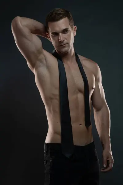 Kravatlı ve kolları başının arkasında olan tişörtsüz bir milyarder.