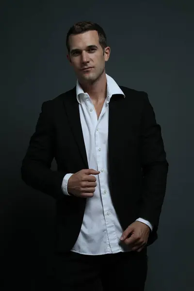 Zarif takım elbiseli adam ileriye bakıyor.