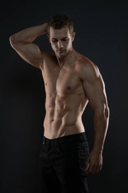Gömleksiz vücut geliştirici hafifçe döndü ve aşağıya baktı.