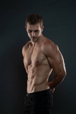 Tişörtsüz Adam aşağıya bakıyor ve altılı paketleri gösteriyor