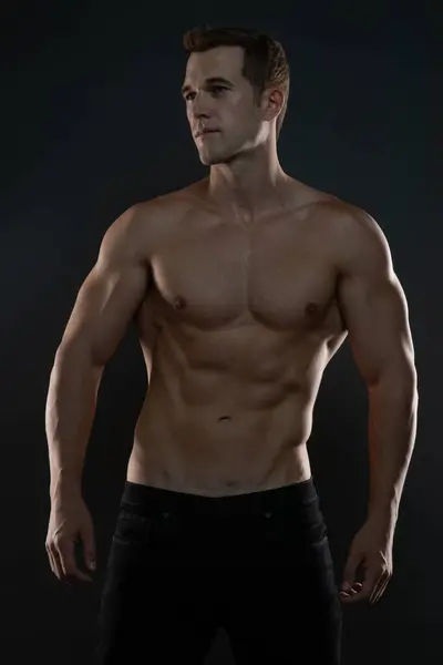 Erkek Modeli Gömleksiz kasları ve kasları gösteriyor