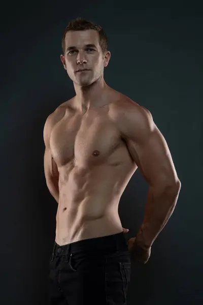 Yakışıklı, genç bir adam. Üstsüz, elleri arkada.