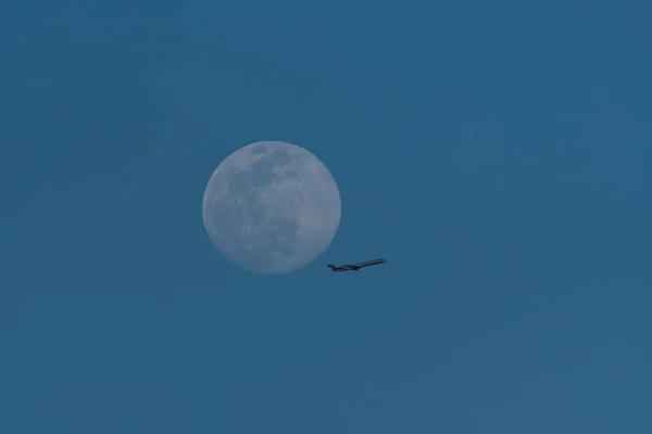 Samolot Pasażerski Przelatujący Przez Prawie Pełnię Księżyca Wysoko Nad Głową — Zdjęcie stockowe