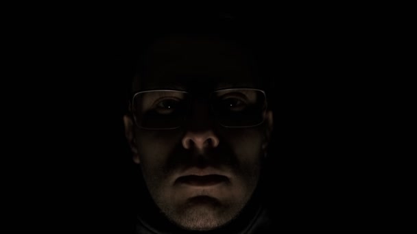 低キー怒りサイコパスの感情の黒い背景にカメラを向ける男 恐怖の狂人の顔が右に引く 心の精神障害 — ストック動画