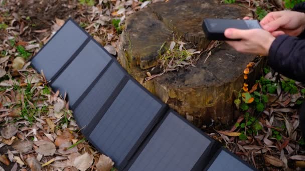 Die Hände Stecken Tragbare Solarzellen Ein Und Laden Multifunktionskabel Smartphone — Stockvideo