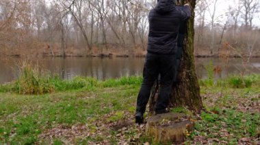 Adam, akıllı telefonu elektrik kablosu, elektrik bankası, saatler ve dizüstü bilgisayarla şarj ettiği için ağaca güneş paneli asıyor. Kamp yapmak için temiz enerji ya da elektrik olmadığı zaman evde kullanmak için