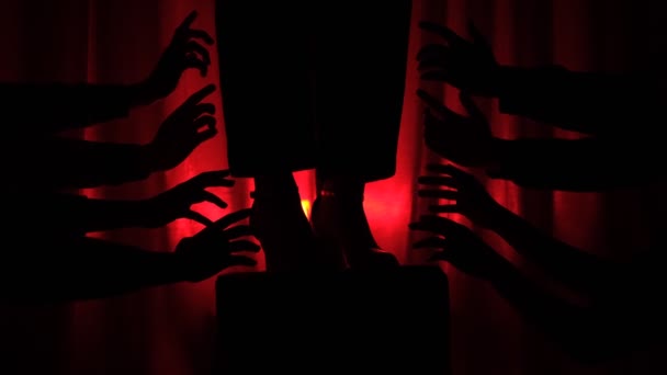 多只手的轮廓试图在红色的黑暗背景下到达舞台上的演员的腿 崇拜的概念 崇拜的人 舞台上的偶像 — 图库视频影像
