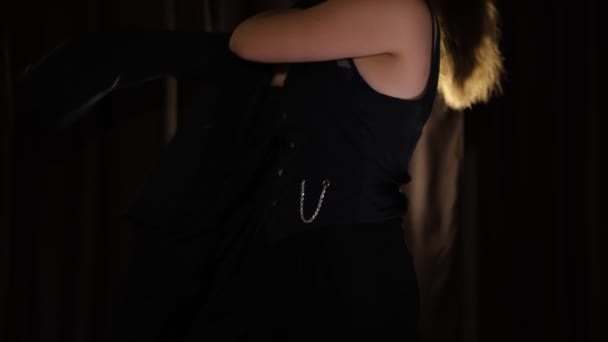 Женщина Модель Одевает Черную Куртку Поверх Жилета Темном Фоне Сцены — стоковое видео