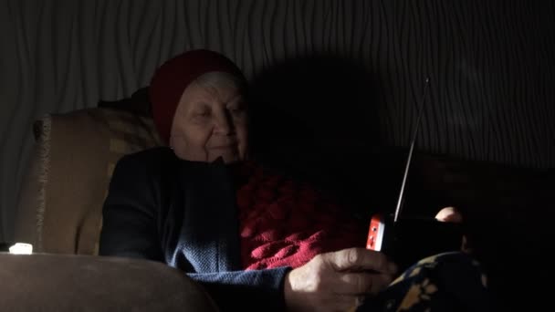 Ukraina Babcia Trzyma Radio Rękach Siedząc Ciemności Podczas Rosyjskich Ataków — Wideo stockowe