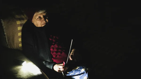 우크라이나 할머니는 러시아의 공격중에 어둠의 라디오를 소파에 나이든 라디오 수신기로 로열티 프리 스톡 사진
