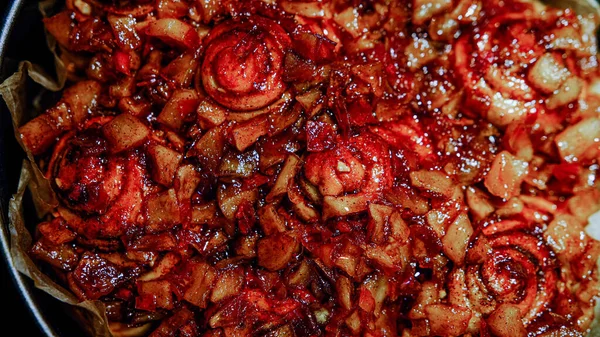 用羊皮纸在黑炉子背景上自制的红色美味苹果派 — 图库照片