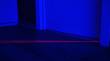 Spor aletleri, kırmızı ışıkla kapıdan süzülen neon ışıklı tenis topu. Neon yeşil tenis topuyla mavi ve kırmızı renkler.