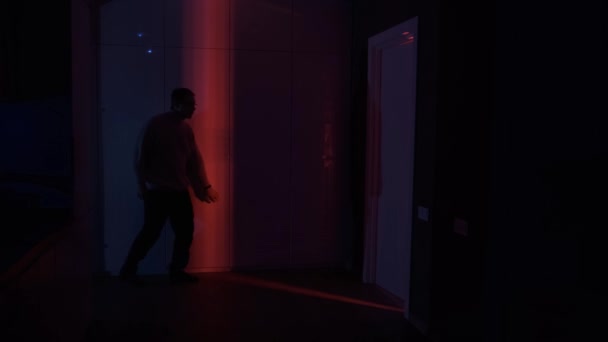 Man Silhouet Kruipt Rond Tenen Het Rode Licht Van Het — Stockvideo