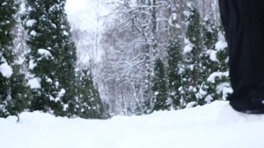 Anne, kız ya da kadın kışın ormanda kızaklar ve arka planda beyaz kış manzarasıyla yürüyor..