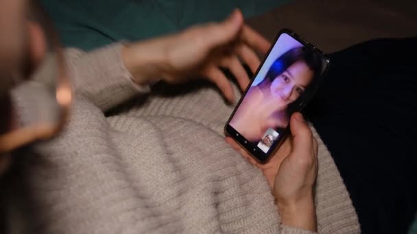 Young Man Sitting Sofa Holding Smartphone Communicating Girl Friend Mobile — Stockvideo