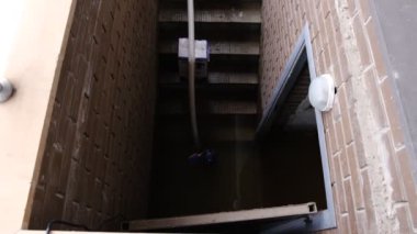 Recently flooded basement seen with a large pipe and pump used to pump out flooded basement water. The flooded basement of the house.