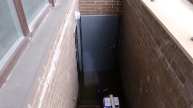 Recently flooded basement seen with a large pipe and pump used to pump out flooded basement water. The flooded basement of the house.