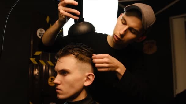 Young Barber Drying Hair Customer Hair Dryer Barber Shop Dark — 图库视频影像