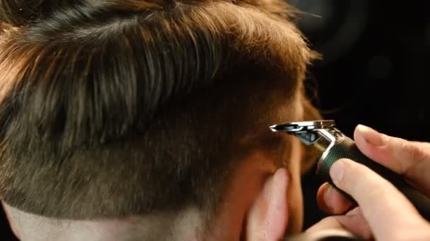 Zbliżenie Ujęcie Przystojnego Fryzjera Robiącego Fryzurę Swojemu Klientowi Używając Trymera — Wideo stockowe